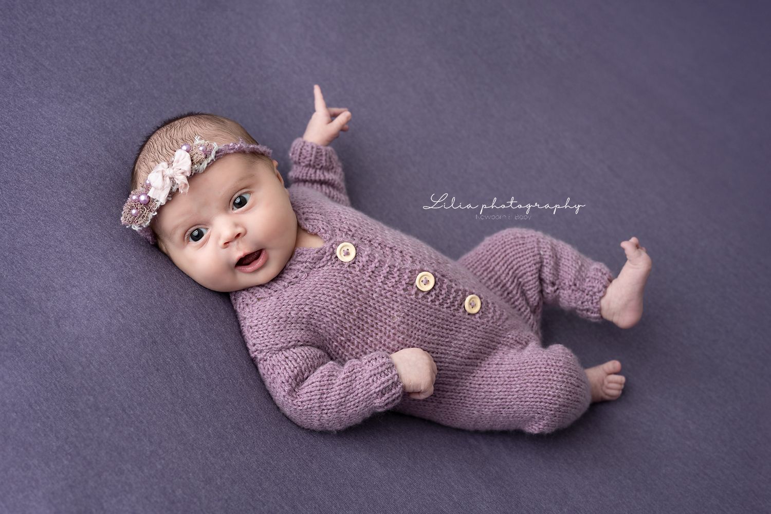 Sitting baby photographed on a neutral backdrop